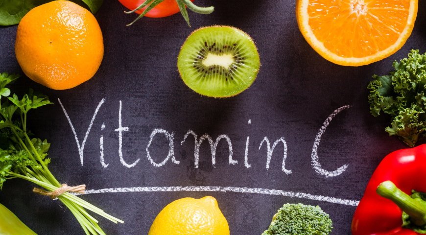 Fruits and vegetables rich in vitamin c with white word inscription by chalk.